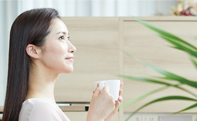 飲み物を持ち笑みを浮かべる女性